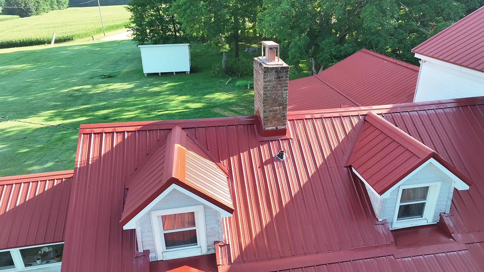 Classic panel metal roof and porch on a red farm home in Hartsville, Tennessee