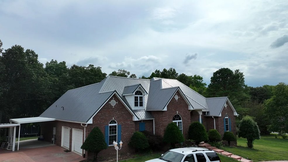 Silver standing seam metal roof and roofline on a family home in Forest Hills, TN