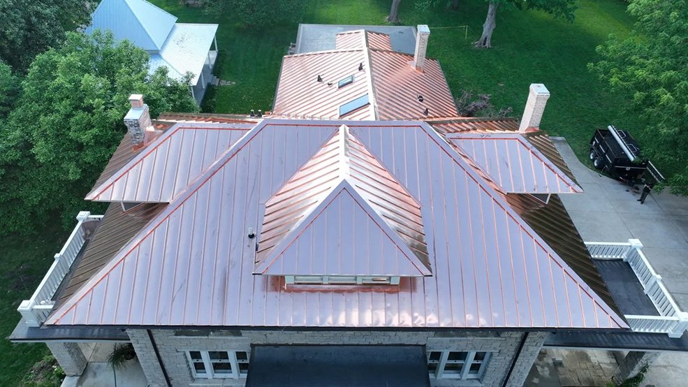 Copper standing seam metal roof on a century old stone home in Franklin, TN