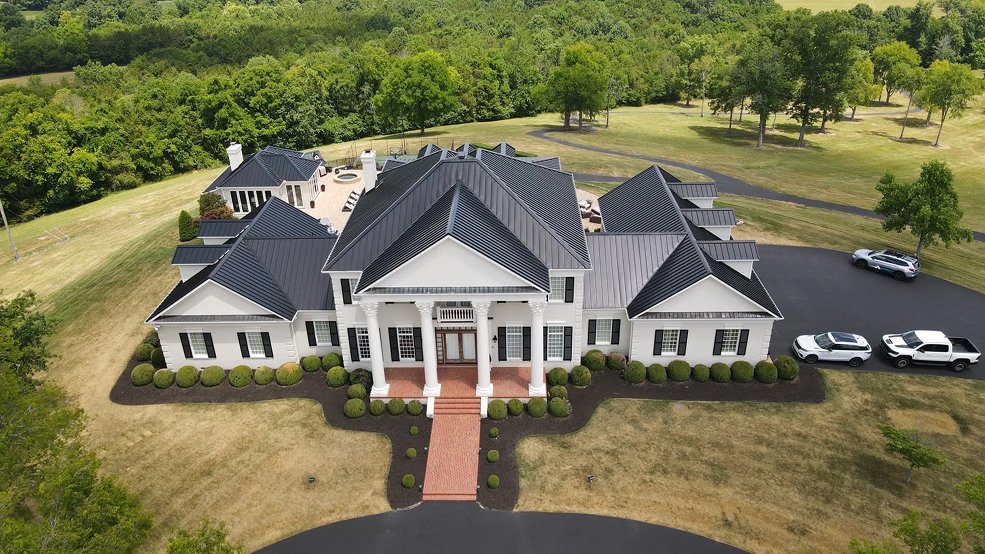 Mansard brown standing seam metal roof on a Tudor home in Brentwood, Tennessee
