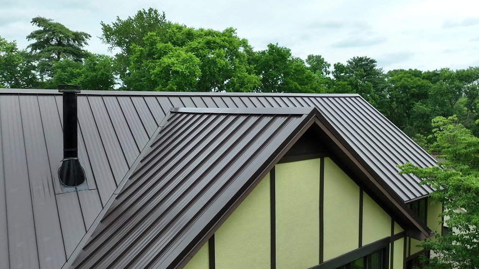 Mansard brown standing seam roof and steep slope on a Tudor home in Brentwood, TN