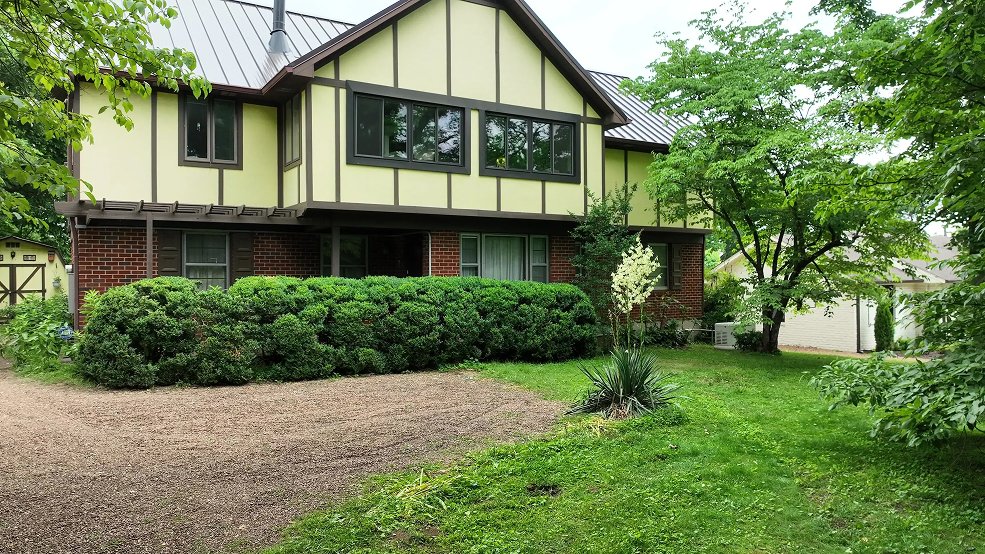 Mansard brown standing seam metal roof on a Tudor style home in Brentwood, TN