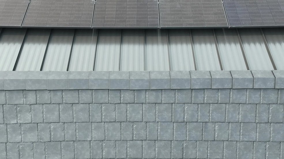 Black steel shingles and standing seam panels carrying a solar array