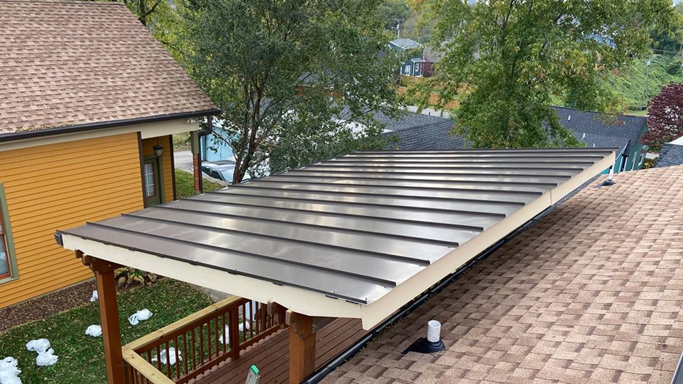 Gray standing seam metal roof over a covered porch