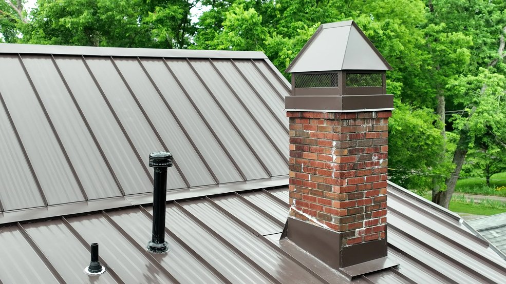 Mansard brown standing seam metal roof and upper story on a Tudor home in Brentwood, TN