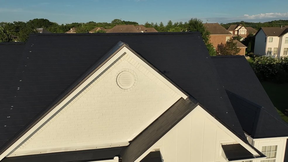 Metal shingle roof catching low evening sunlight