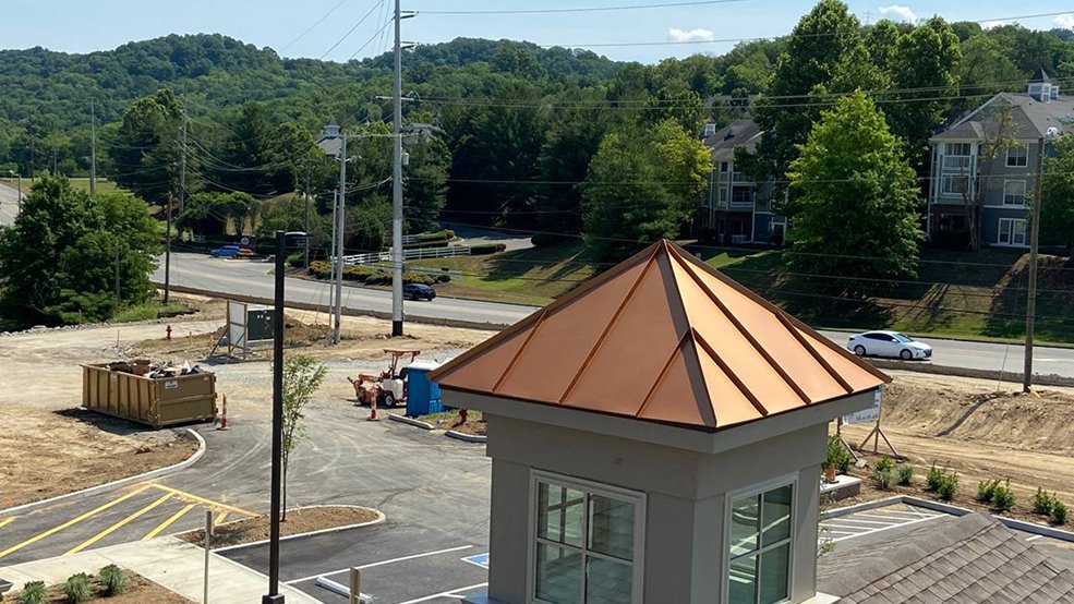 Copper standing seam panels formed around a turret
