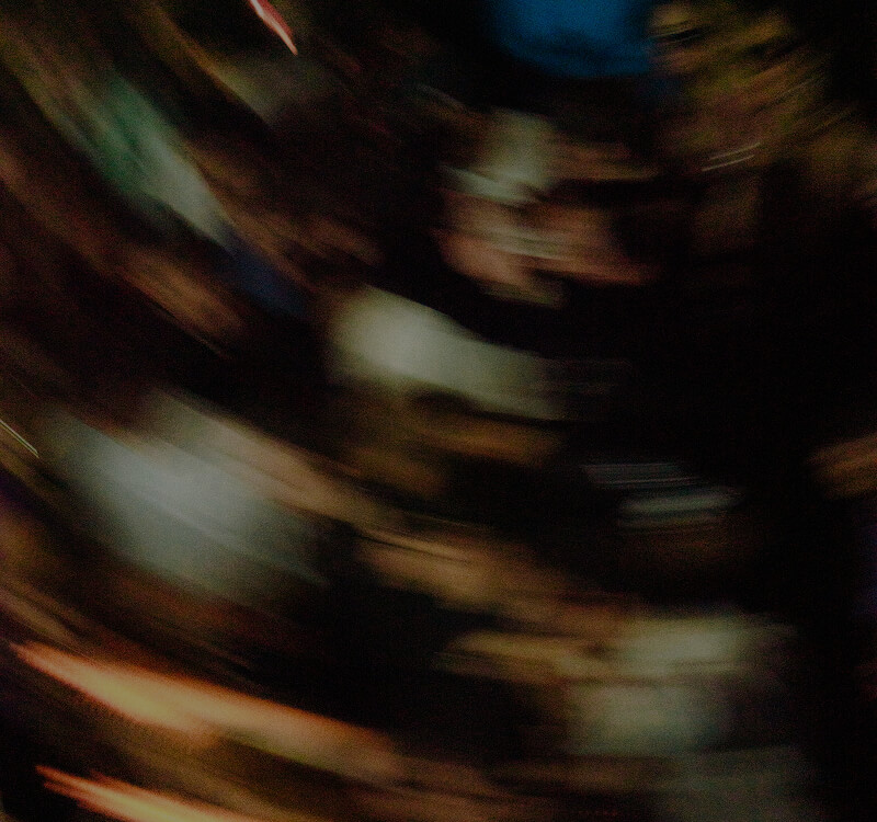 Blurred and dark image with indistinct shapes and streaks of light.