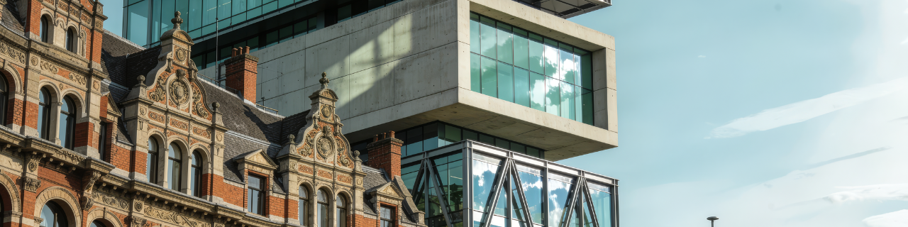 Historisch gebouw naast moderne glazen kantoorarchitectuur als visualisatie van continuïteit en herhaalbaarheid in ESG-rapportage