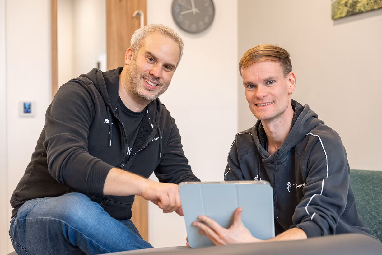 Zwei Physiotherapeuten von PhysioKonzept beraten persönlich am Tablet