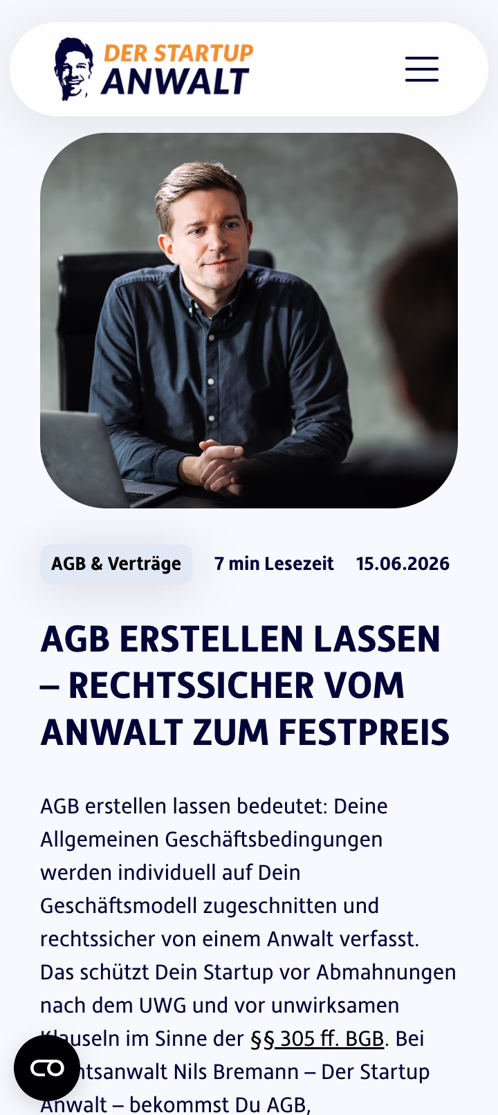 Porträt eines Anwalts in einem dunklen Hemd an einem Schreibtisch mit Laptop.