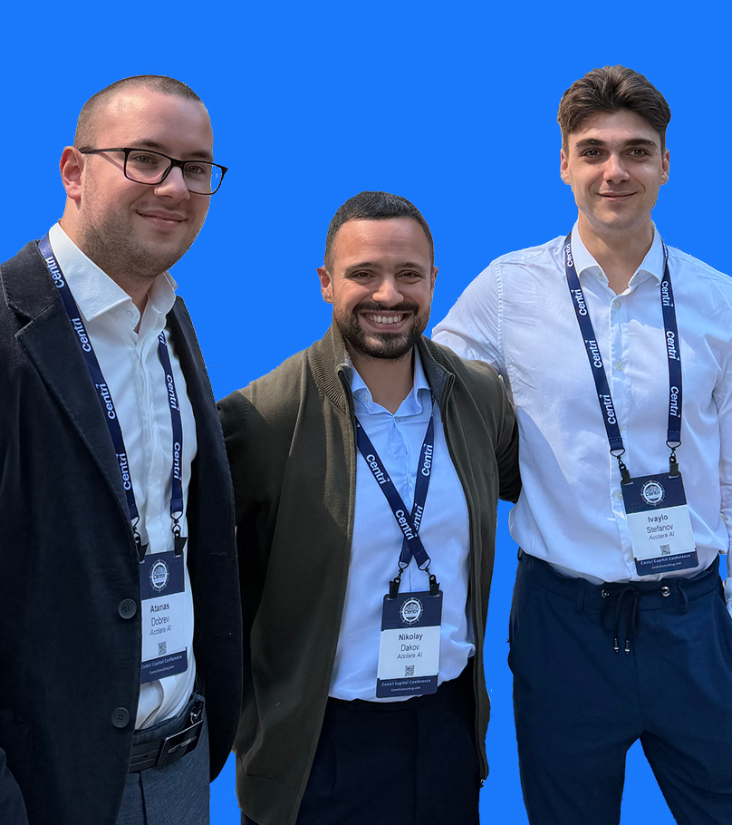 Three men wearing conference badges and lanyards, smiling and standing together against a blue background.