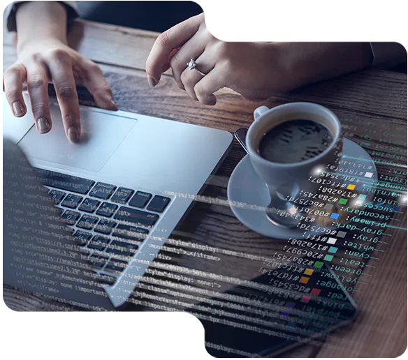 Händer vid bärbar dator med teckenspråksskript och kopp kaffe på trämatsalbord.