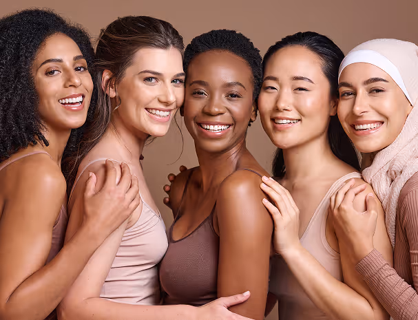 Diverse group of five smiling women close together with their arms around each other