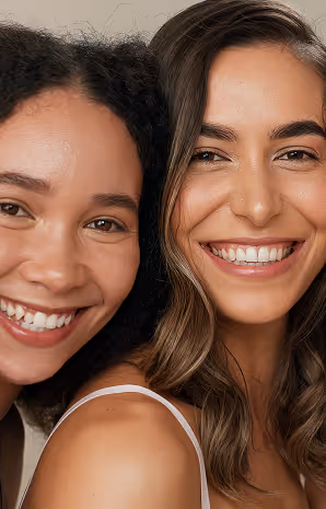 Close-up of two smiling young women with different hairstyles side by side.