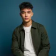 A man in a green jacket is posing for a picture.