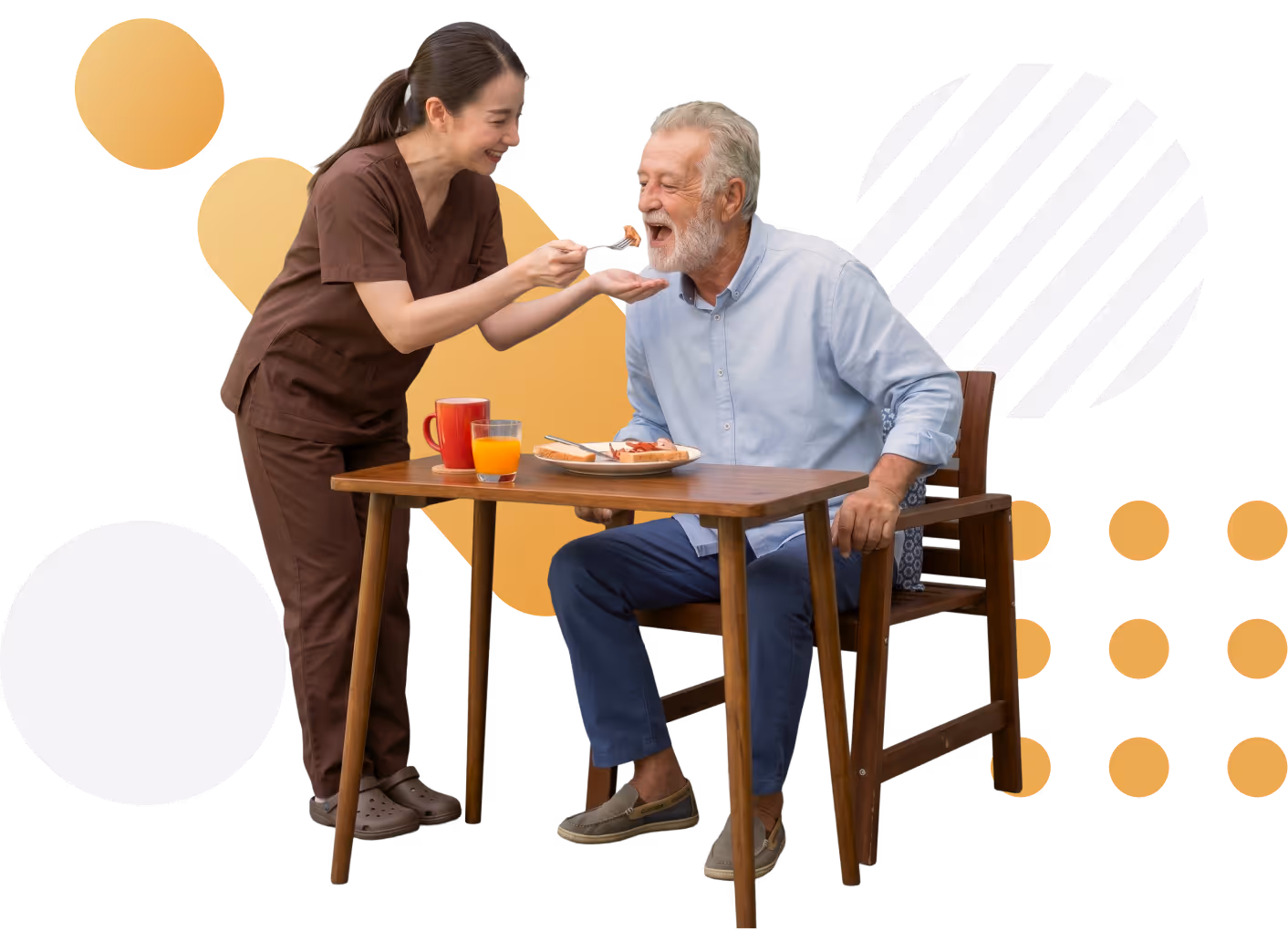 Caregiver feeding elderly man seated at a table with a meal and drinks.