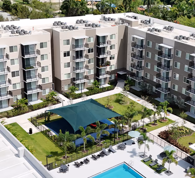 Aerial view of modern apartment complex with pool,  by MT Construction Miami
