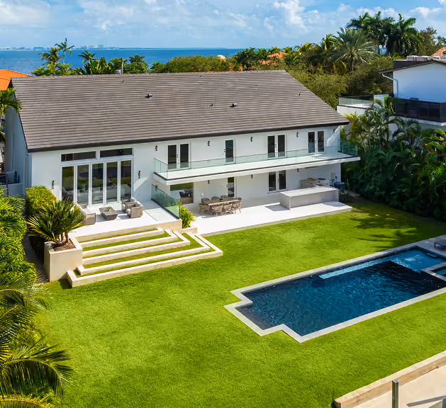 Modern waterfront house with a large green lawn  by MT Construction Miami