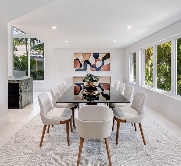 Modern dining room with black table, eight white chairs,  by MT Construction Miami
