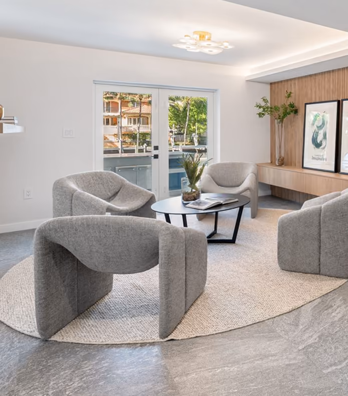Modern seating area with four gray armchairs by MT Construction Miami