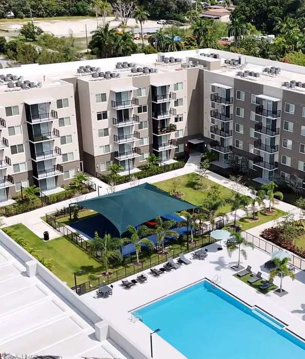 Aerial view of modern apartment complex with outdoor pool,  by MT Construction Miami