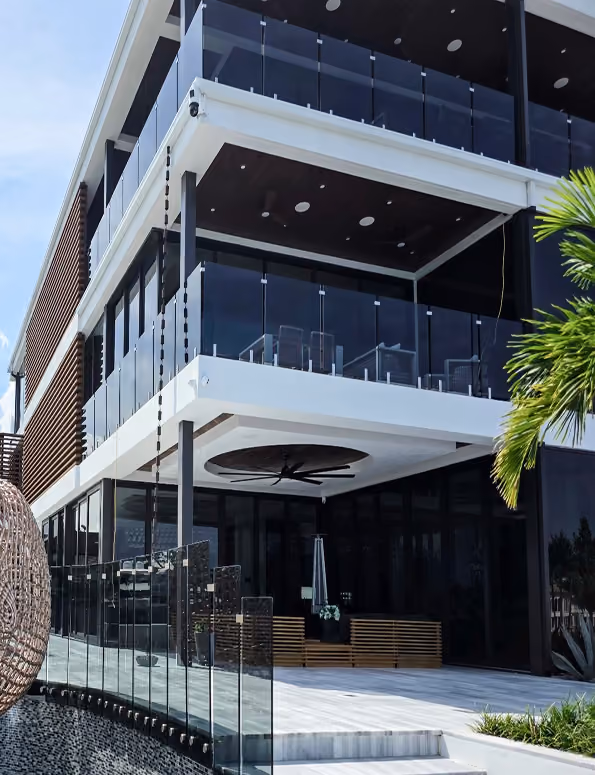 Modern multi-story building with glass balconies,  by MT Construction Miami