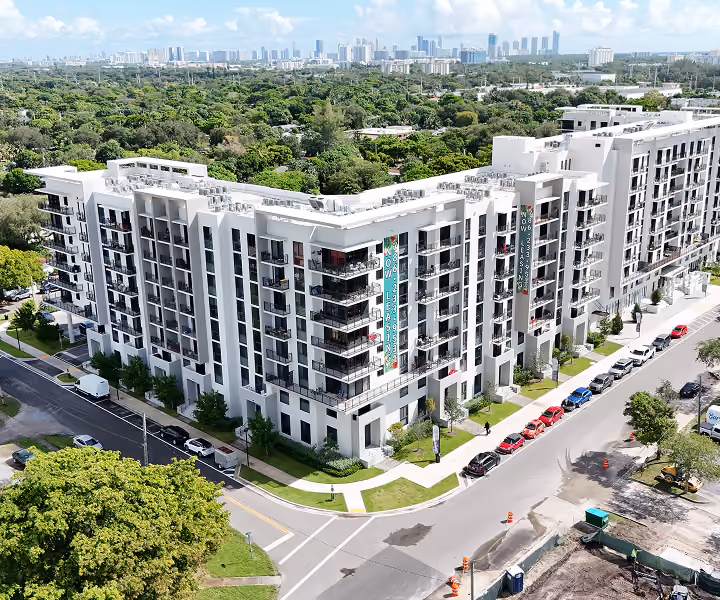 Modern white apartment building at a street corner by MT Construction Group Miami
