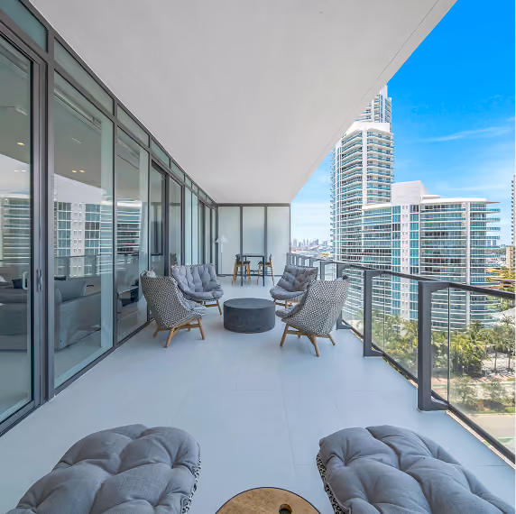 Modern balcony seating area with cushioned chairs by MT Construction Group Miami