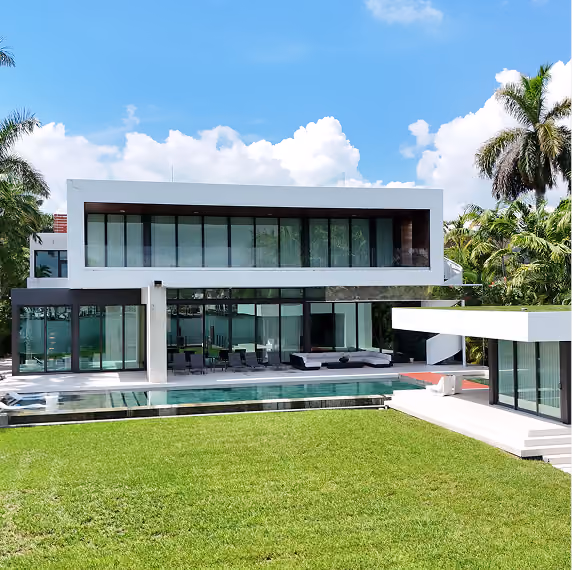 Modern two-story house with large glass windows, by MT Construction Group Miami 