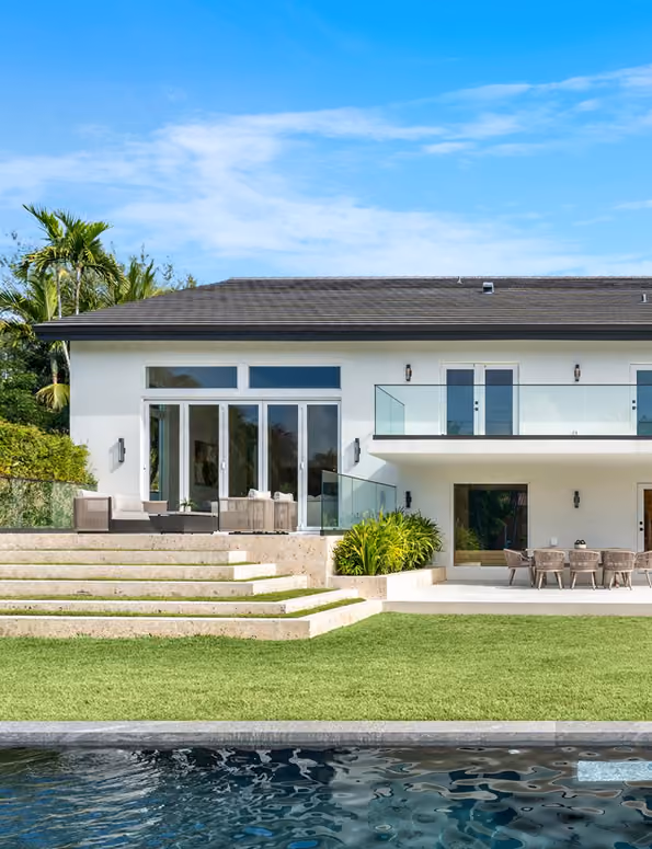 Modern two-story white house with glass balcony,  by MT Construction Miami