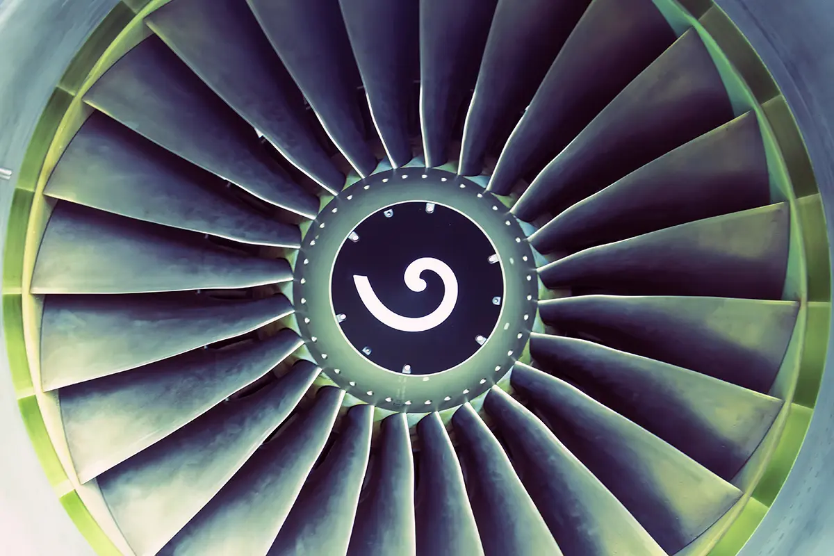 Close-up view of turbine blades arranged in a circular pattern with a spiral design at the centre.