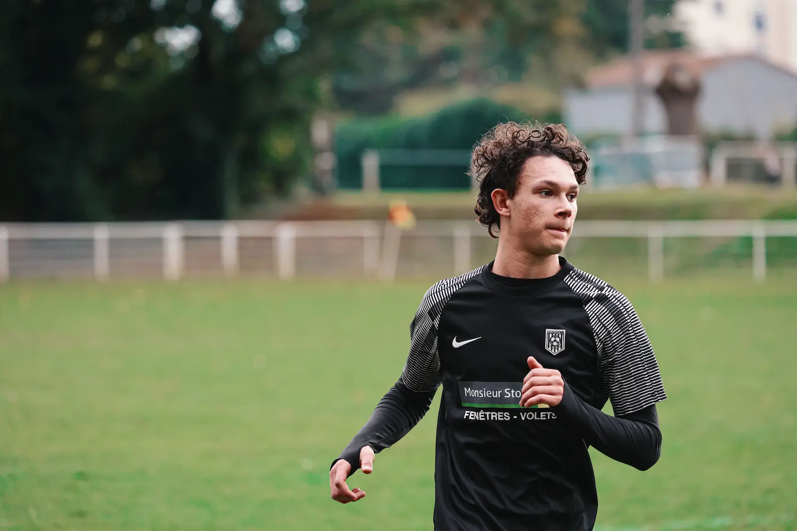 Photographie d’un jeune homme d’une équipe de football de La Ligugéenne en train de courir, son visage affiche un effort.