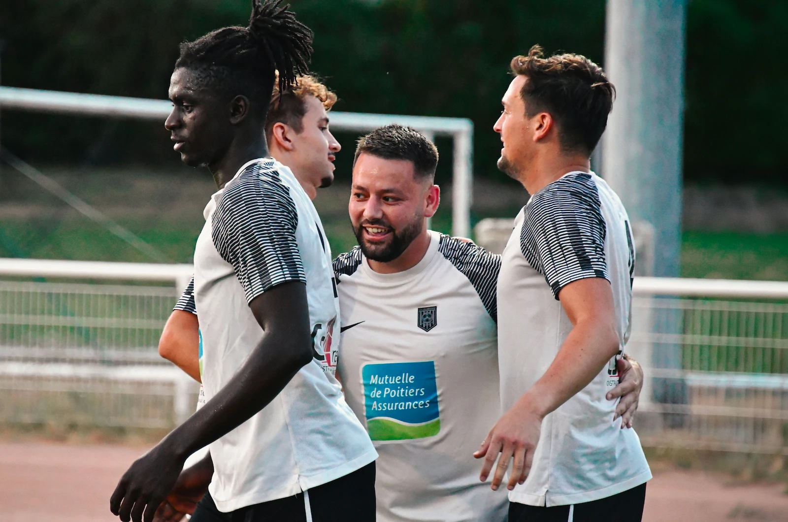 Photo d'un groupe de joueurs de La Ligugéenne, célébrant un but sur un terrain de foot.
