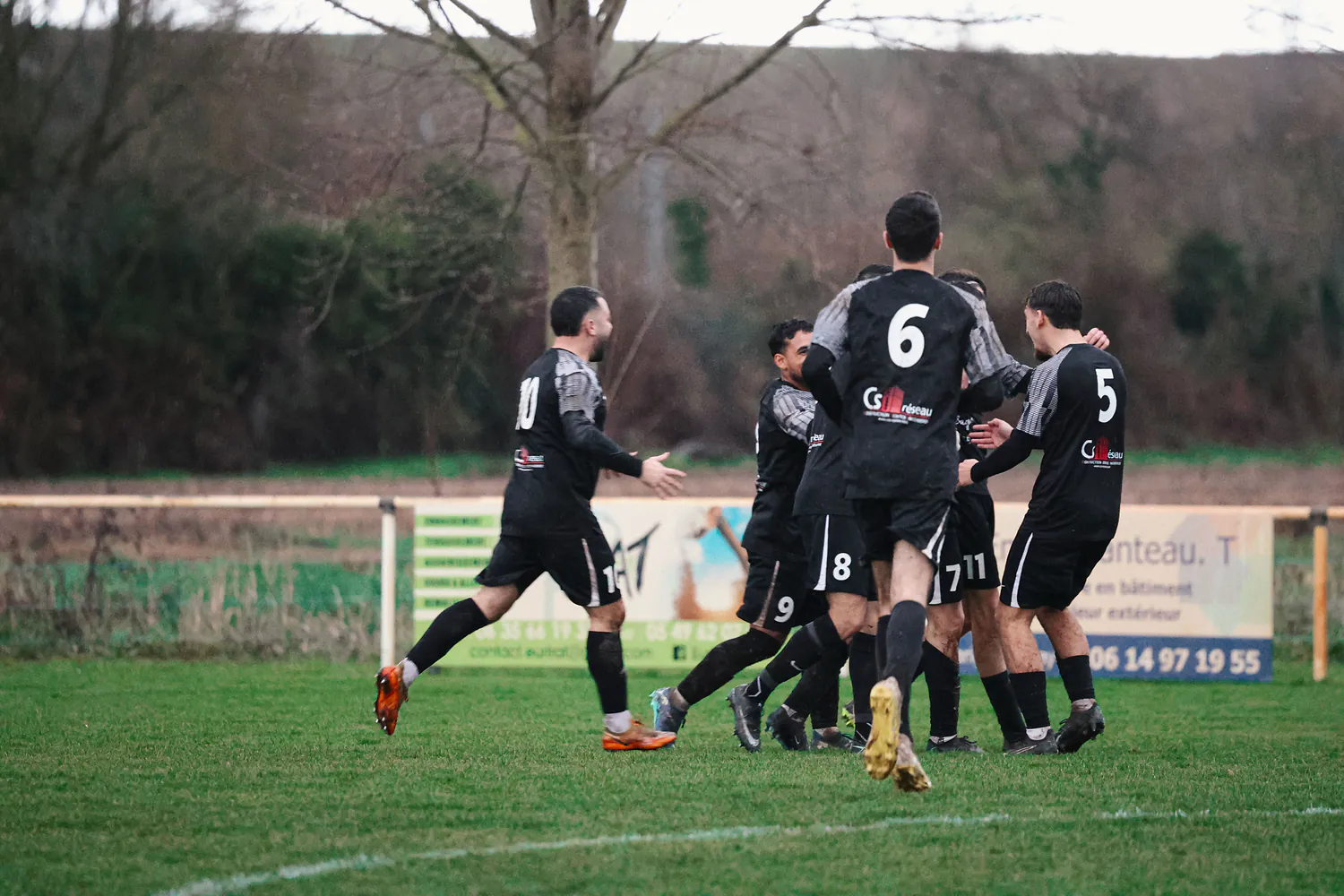 Photo d'un groupe de joueurs de La Ligugéenne, célébrant un but sur un terrain de foot