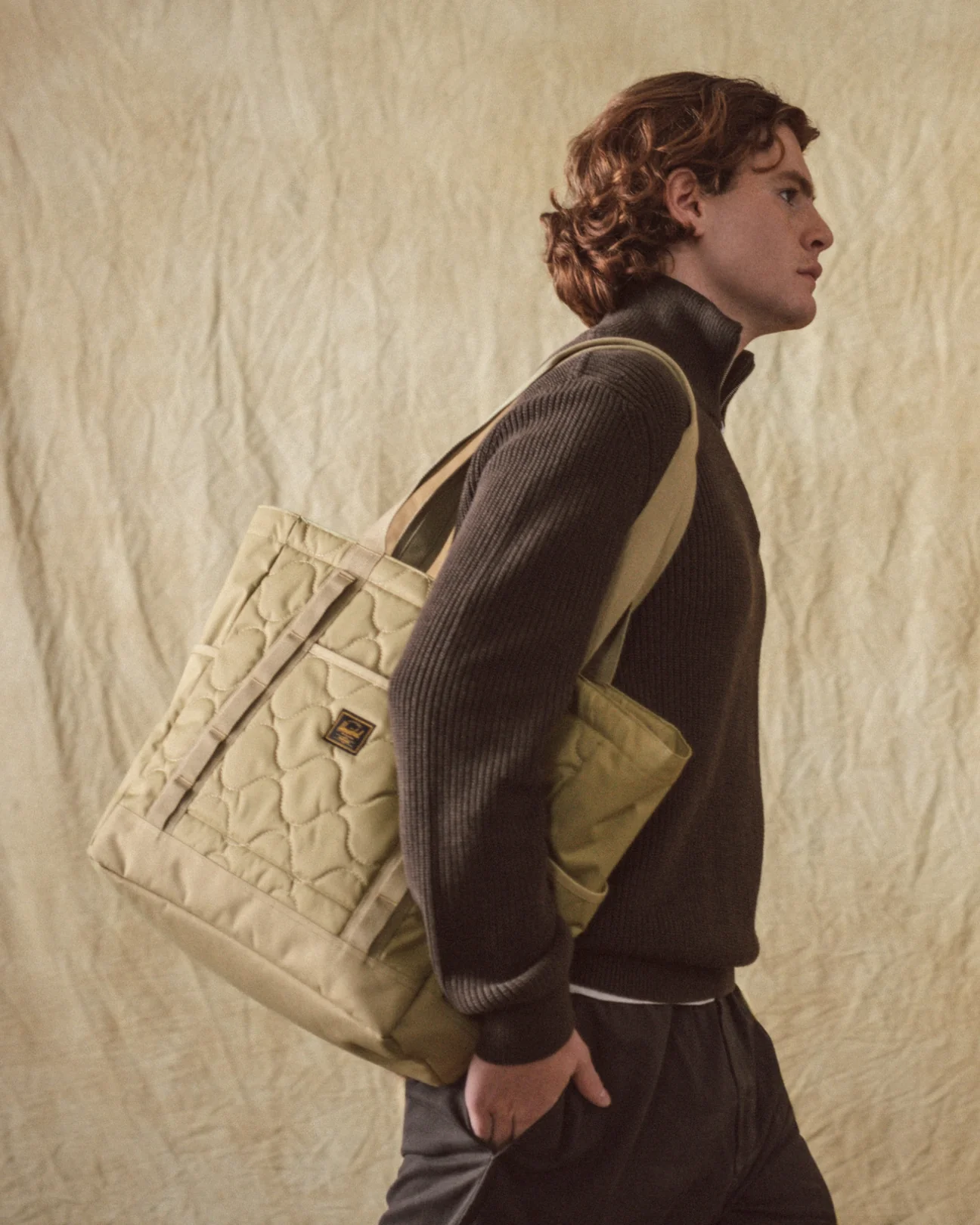 Herschel Supply Co. quilted tote carried on the shoulder