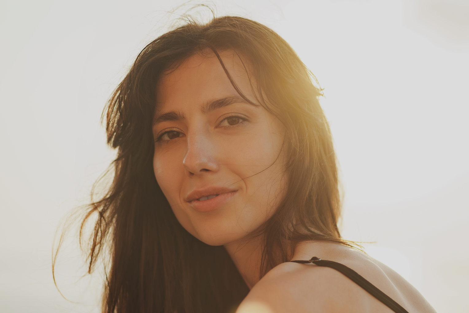 woman smiling with sunshine background