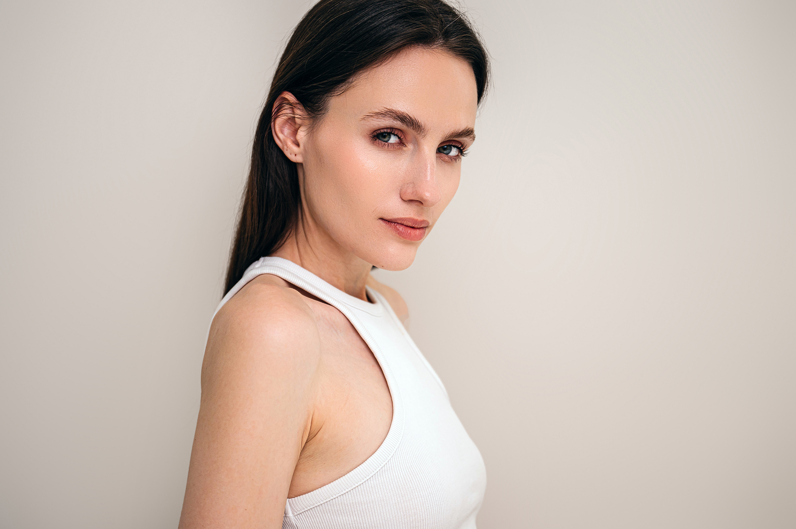 woman in white tank top looking at camera