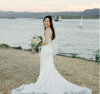 Bride in wedding gown by the lake with bouquet
