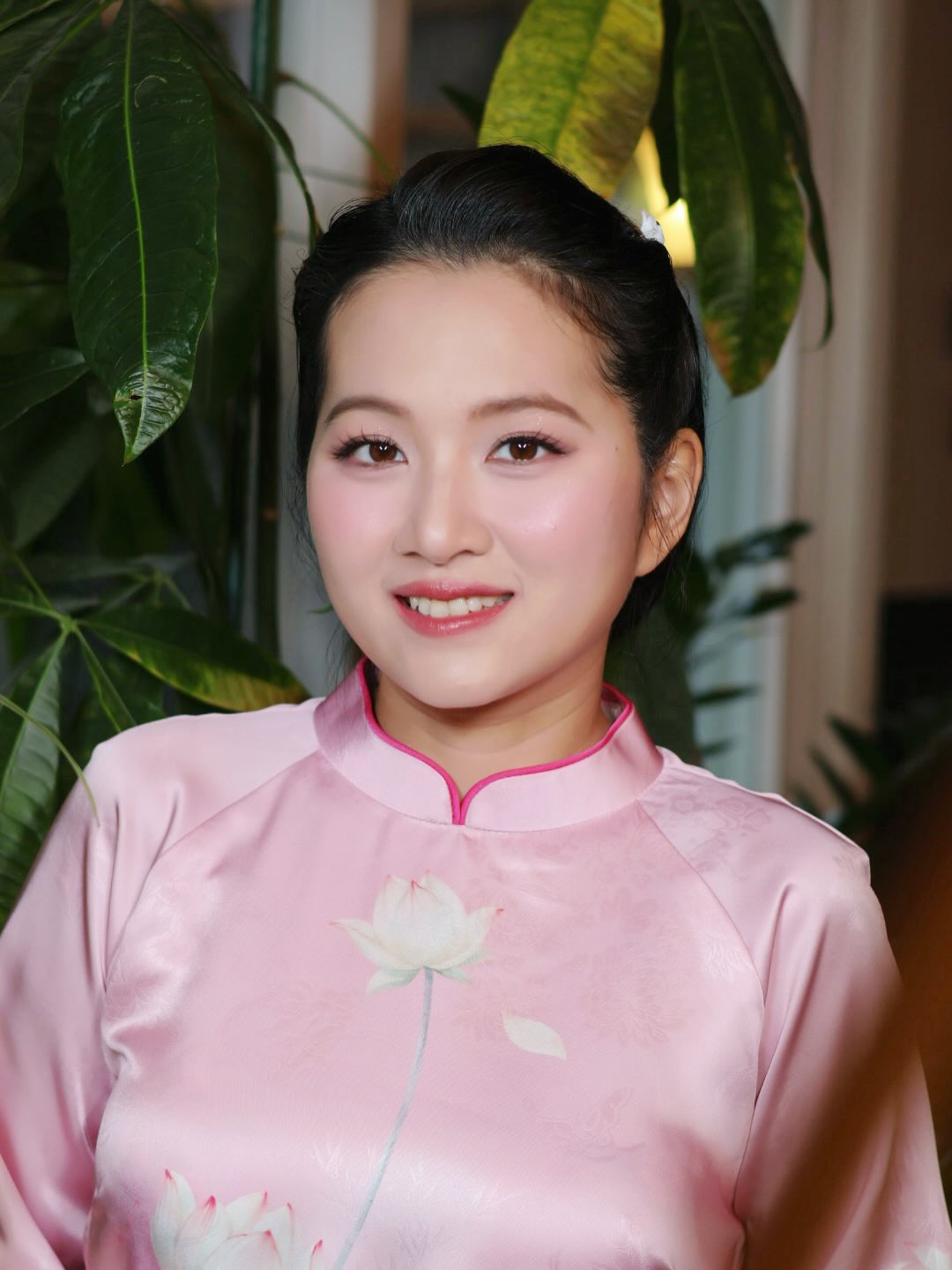 Bridal makeup portrait in pink áo dài with elegant updo