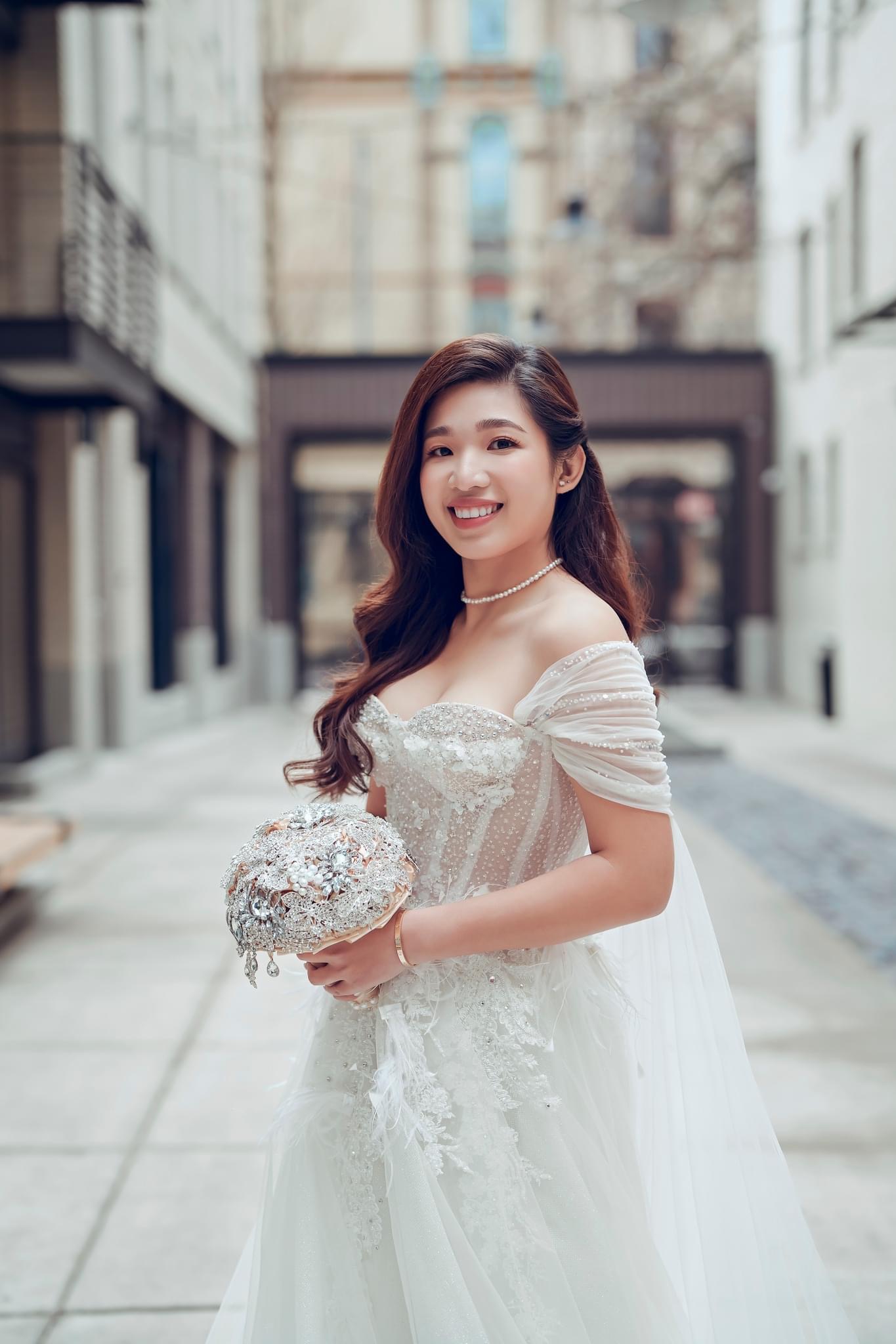Bride holding white bouquet with soft glam wedding makeup