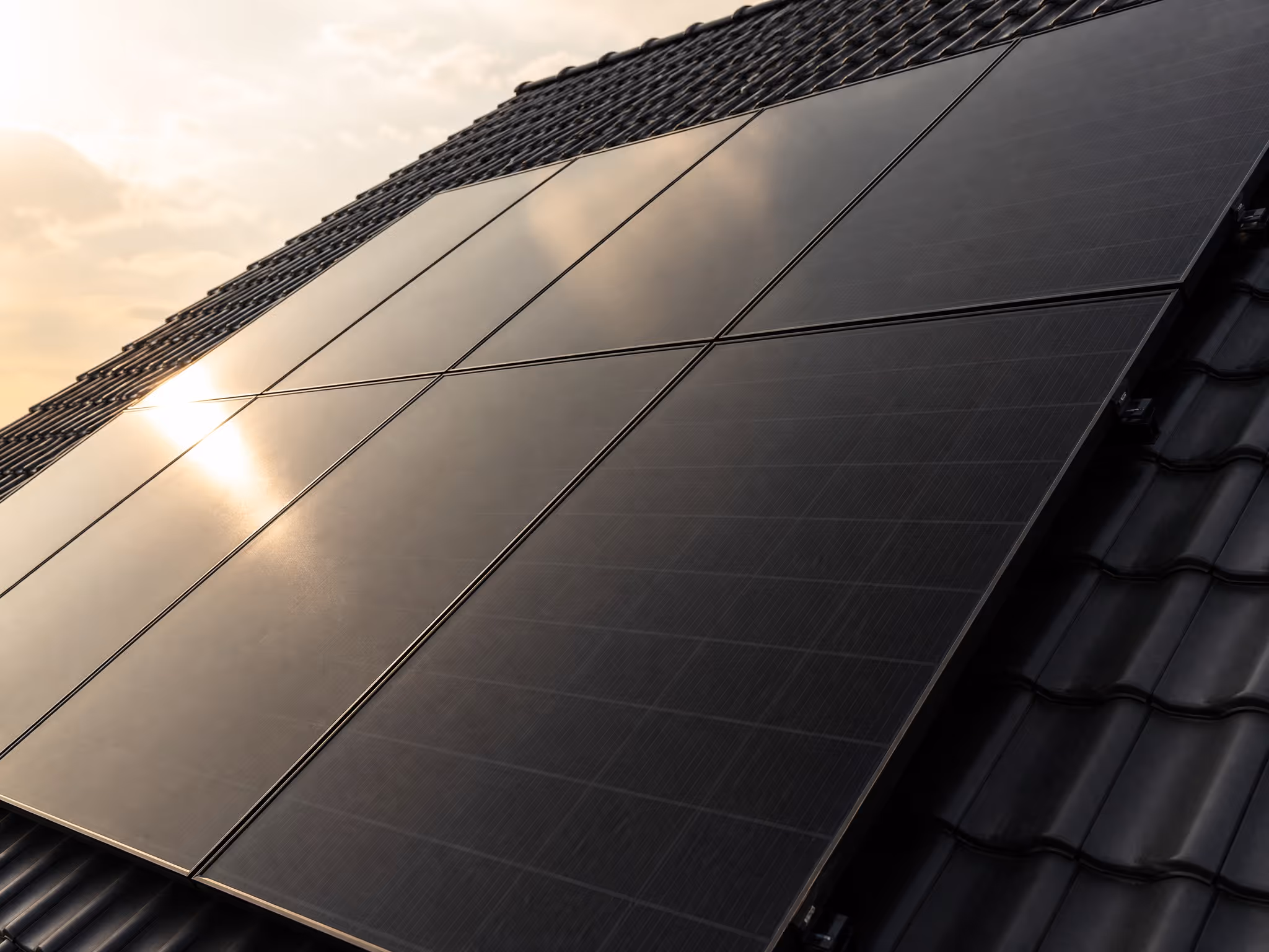 All-Black Solarmodule auf einem Dach in Bremen mit goldenem Sonnenreflex