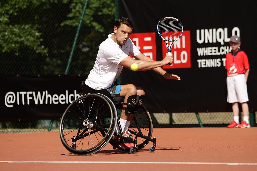 Personne en situation de handicap moteur jouant au tennis adapté