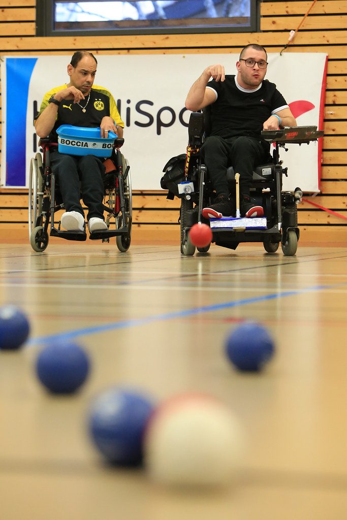 Deux joueurs en situation de handicap moteurs en train de jouer au boccia