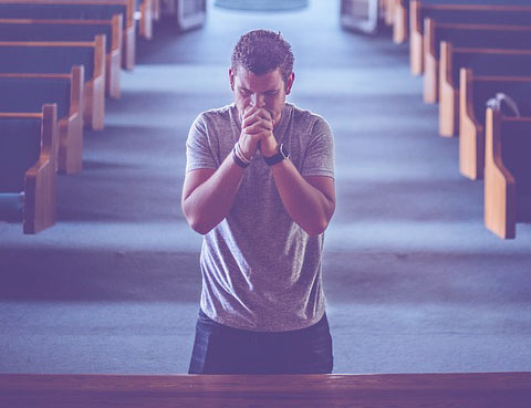 Photo of a praying man in church
