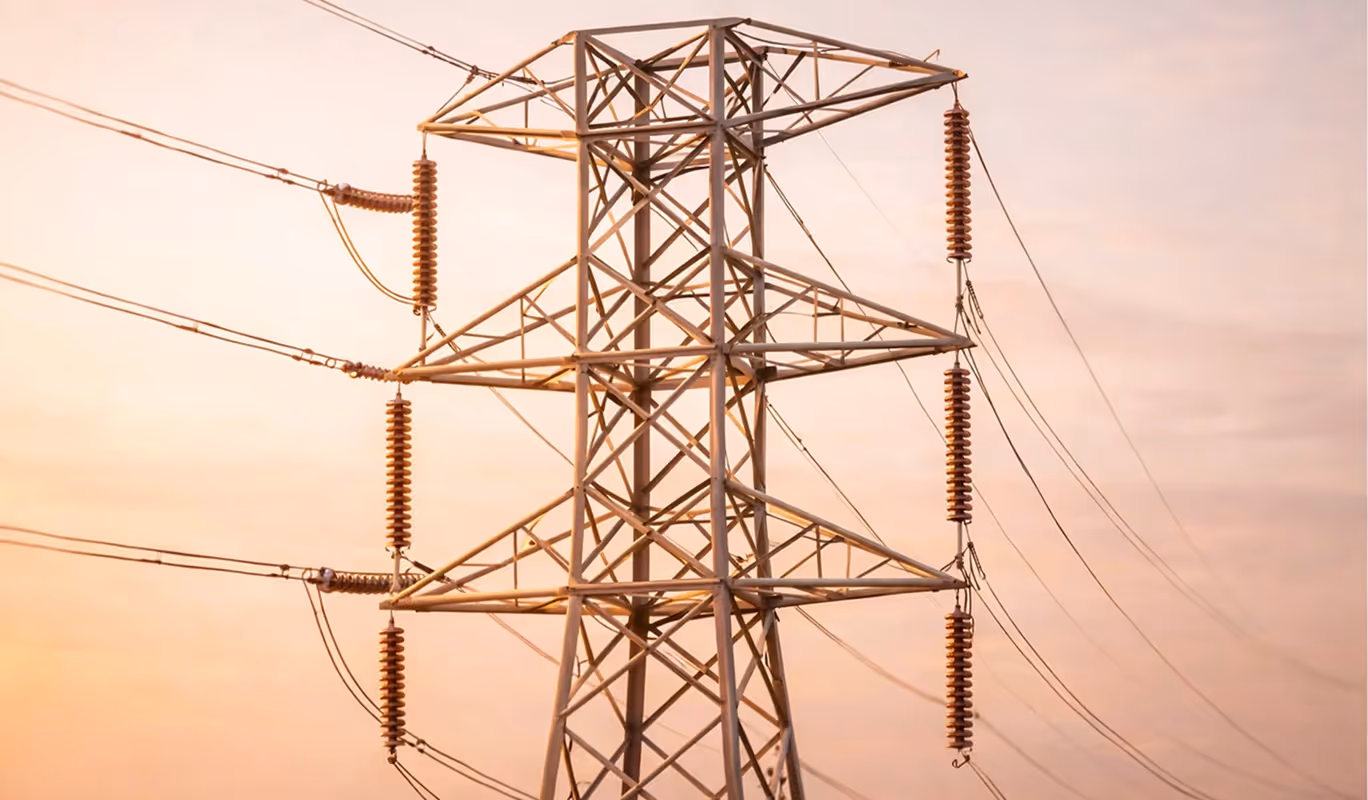 High-voltage electrical distribution lines and towers spanning across an open landscape.