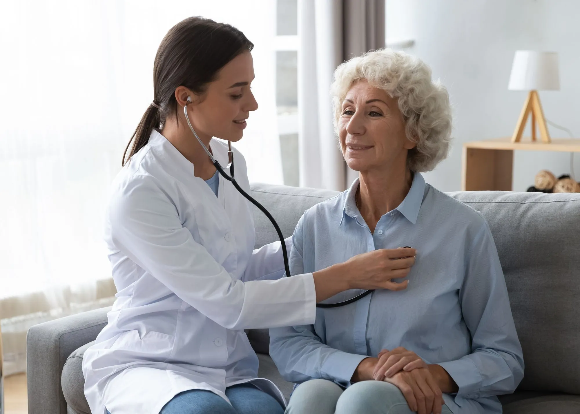 A doctor checking the heartbeat of a patient.