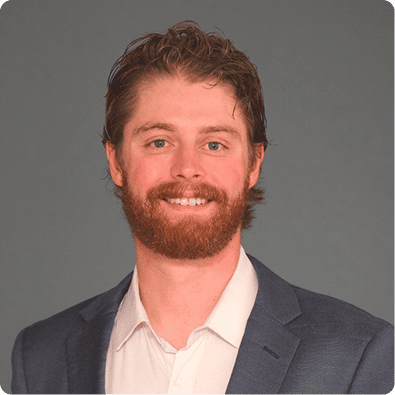 Portrait of A.J. Curtin, Founder at Xcite Analytics, smiling in a blazer against a neutral background, accompanied by a bio highlighting his expertise in identifying opportunities and translating market insights into actionable investment strategies.