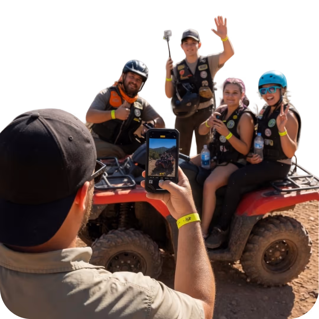 Tour guide taking a picture of a happy family posing on an ATV