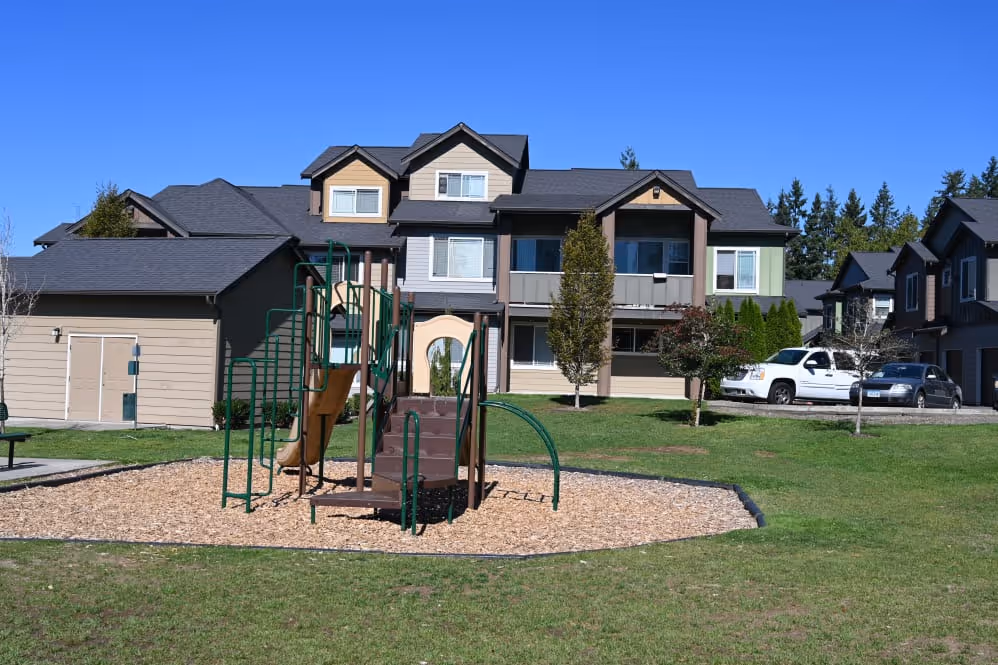 Playground near grass and building Bella on Canyon Apartment Homes for Rent